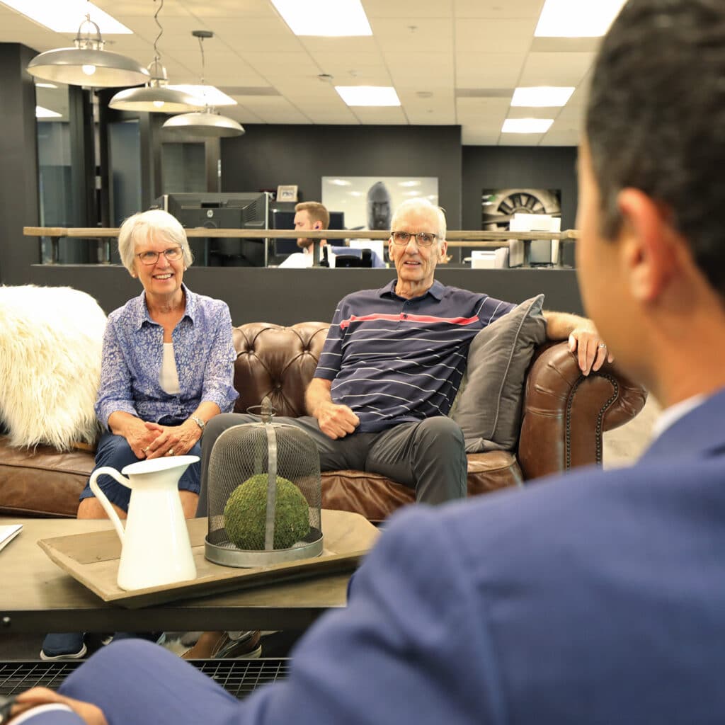 Elderly couple receiving financial advice while sitting on couch