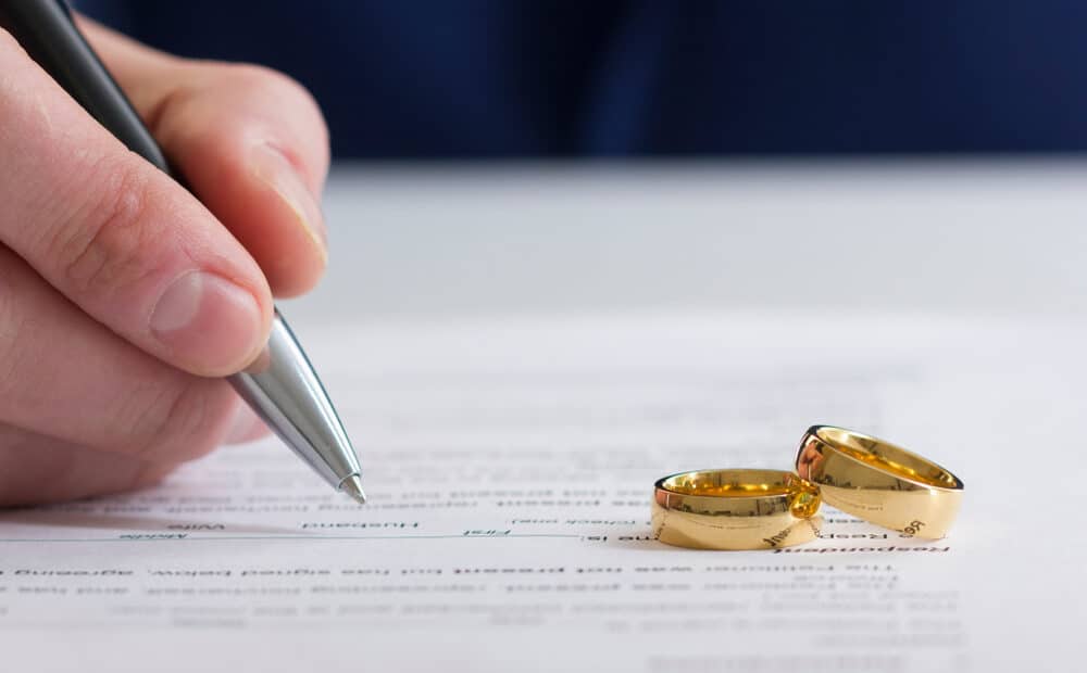 Wedding rings stacked on a decree of divorce